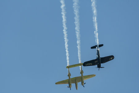 Mollis, Switzerland, August 18, 2023 Lockheed P-38L Lightning and a Chance Vought F4U-4 Corsair historic aircraft in formation flight during an air displayのeditorial素材