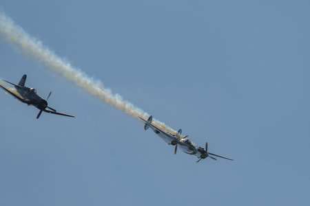 Mollis, Switzerland, August 18, 2023 Lockheed P-38L Lightning and a Chance Vought F4U-4 Corsair historic aircraft in formation flight during an air displayのeditorial素材