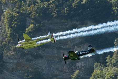 Mollis, Switzerland, August 18, 2023 Lockheed P-38L Lightning and a Chance Vought F4U-4 Corsair historic aircraft in formation flight during an air showのeditorial素材