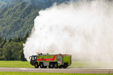 Mollis, Switzerland, August 18, 2023 Firefighter truck presentation with splashing water during an air showのeditorial素材