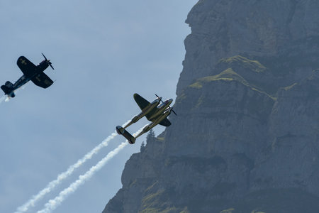 Mollis, Switzerland, August 18, 2023 Lockheed P-38L Lightning and a Chance Vought F4U-4 Corsair historic aircraft in formation flight during an air displayのeditorial素材