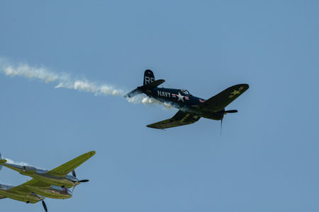 Mollis, Switzerland, August 18, 2023 Lockheed P-38L Lightning and a Chance Vought F4U-4 Corsair historic aircraft in formation flight during an air displayのeditorial素材