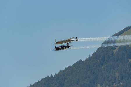 Mollis, Switzerland, August 18, 2023 Lockheed P-38L Lightning and a Chance Vought F4U-4 Corsair historic aircraft in formation flight during an air displayのeditorial素材