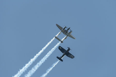 Mollis, Switzerland, August 18, 2023 Lockheed P-38L Lightning and a Chance Vought F4U-4 Corsair historic aircraft in formation flight during an air displayのeditorial素材