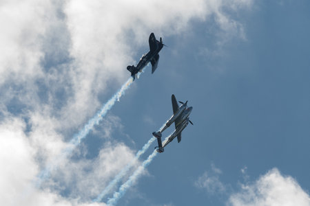 Mollis, Switzerland, August 18, 2023 Lockheed P-38L Lightning and a Chance Vought F4U-4 Corsair historic aircraft in formation flight during an air displayのeditorial素材
