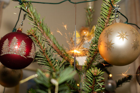 Ruggell, Liechtenstein, December 24, 2022 Burning bengal fire during christmas celebration on a fir treeの写真素材