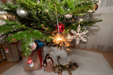 Ruggell, Liechtenstein, December 24, 2022 Burning bengal fire during christmas celebration on a fir treeの写真素材