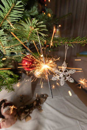 Ruggell, Liechtenstein, December 24, 2022 Burning bengal fire during christmas celebration on a fir treeの写真素材