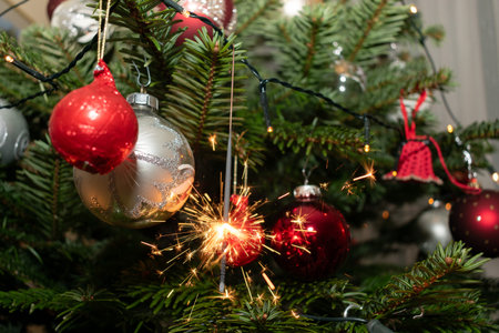 Ruggell, Liechtenstein, December 24, 2022 Burning bengal fire during christmas celebration on a fir treeの写真素材