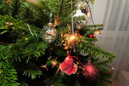 Ruggell, Liechtenstein, December 24, 2022 Burning bengal fire during christmas celebration on a fir treeの写真素材
