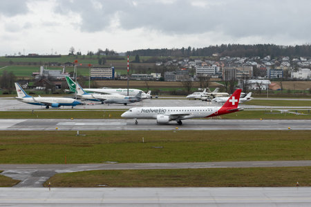 Zurich, Switzerland, January 18, 2024 HB-AZG Helvetic Airways Embraer E190-E2 aircraft is taxiing to its position on a rainy dayのeditorial素材