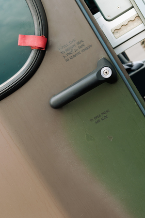Closeup of military helicopter door with handle and writingsの写真素材