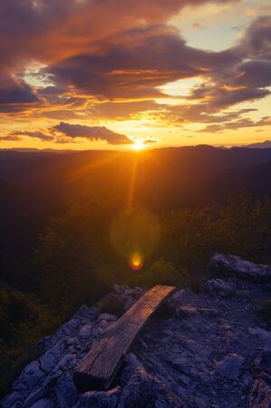 Beautiful sunset and colorful clouds over landscape from top of the hill. Hiking, self-reflection,...