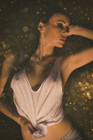 Sexy young woman with big breast. Girl posing on golden  wallの写真素材