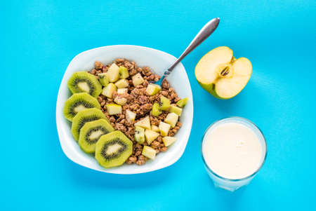 Muesli with kiwi and apple with milk on  blueの写真素材