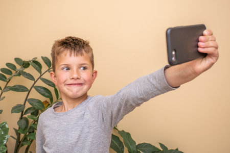 cheerful little boy taking a selfie on a smartphone.