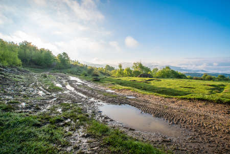puddles on a background of meadows and mountains at sunrise.の写真素材