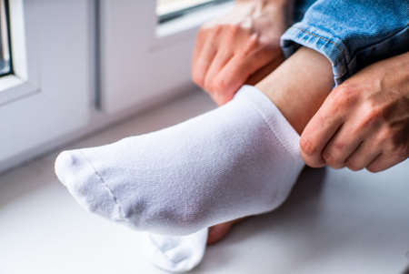 girl wears white socks close-up. chiropody.の写真素材