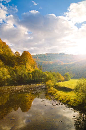 View of the river idyllic landscape when the sun is about to set over the hill on a colorful autumn...