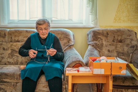 Grandmother knits socks by hand. Digital camera filming commercial video blog or vlog of man teacher...