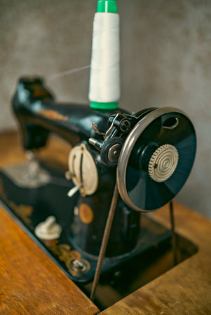Senior woman in spectacles use sewing machine. wrinkled hands of the old seamstress.elderly woman ....