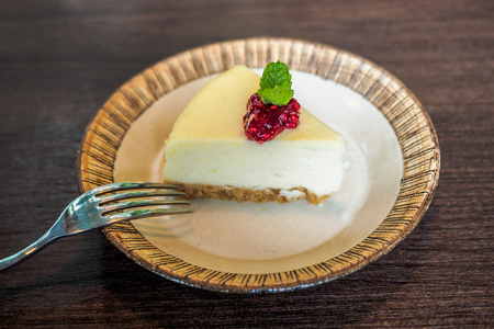 A Cheesecake with a mint leaf and cranberries.の写真素材