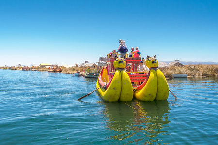 Tourists are riding the traditional reed boat on Lake Titicaca - Oct 3, 2017 - Uros Floating Islands of Puno in Peruのeditorial素材