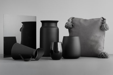 Black Vases and a Pillow with Mirror Reflection on a Gray Surfaceの写真素材