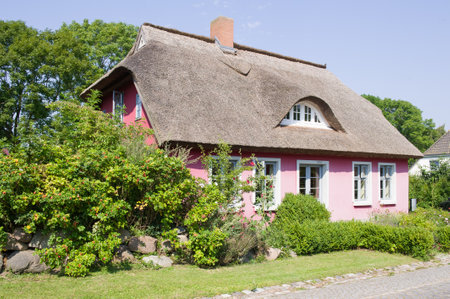 Traditional Thatched Cottage with Pink Walls and Gardenの写真素材