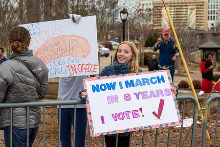 CHARLOTTE, NORTH CAROLINA/USA - February 7, 2020: Young girl holds a warning sign for President Donald Trump' during his appearance in Charlotte, NC on February 7, 2020のeditorial素材