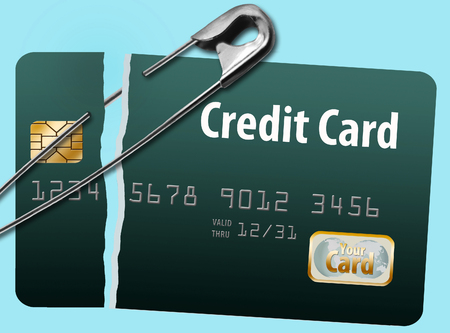 Repairing a bad credit history is illustrated with safety pins holding together a broken credit card.の写真素材