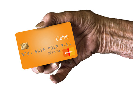 An elderly hand holds a debit card to.の写真素材
