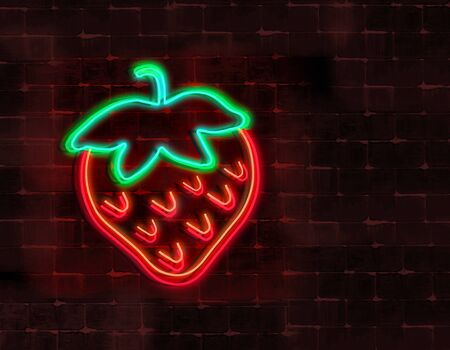 A neon light strawberry is seen glowing in the night and attached to a brick wall. の写真素材