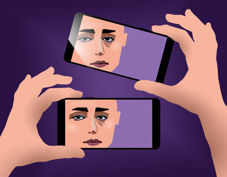 Silhouetted hands hold two cellular phones to make  selfie photographs. Digital art of a female face is seen on both screens.の写真素材