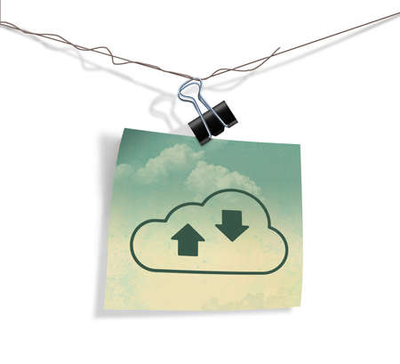 A cloud icon on a piece of grunge covered paper hangs on a wire from a paper clamp in this illustraton about internet cloud services.の写真素材