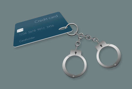 Credit card debt can make someone feel like they are handcuffed to their debt. Here is a pair of handcuffs attached to a credit card.の写真素材