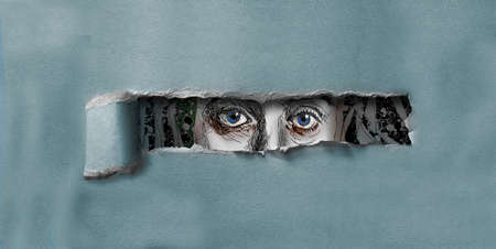 A female with blue eyes peers through a hole torn in cardboard in this 3-d illustration.