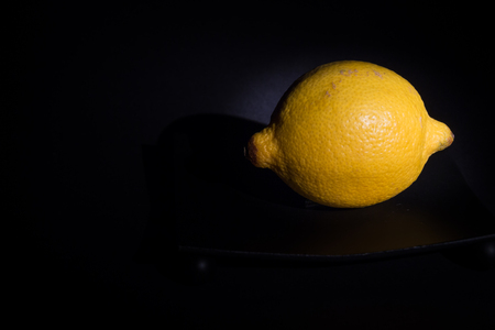 Yellow Lemon in front of black backgroundの写真素材