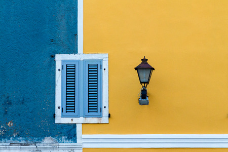 Facade in blue and yellow with windows and street light