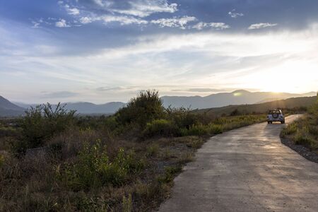 off-road-vehicle is driving into the sunset