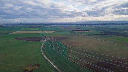 Aerial view of a power line in the middle of a fieldの写真素材