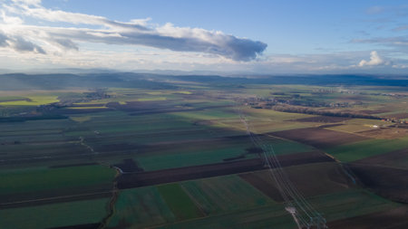 Aerial view of a power line in the middle of a fieldの写真素材