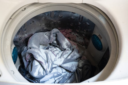 LG washing top view turned on and opened door, with clothes inside and detergentの写真素材