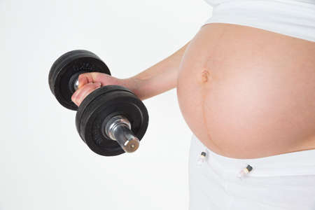Sportive pregnant woman with dumbbellの写真素材