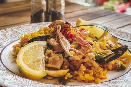 Seafood traditional Spanish paella rice dish with lemon and mussels blurred backgroundの写真素材