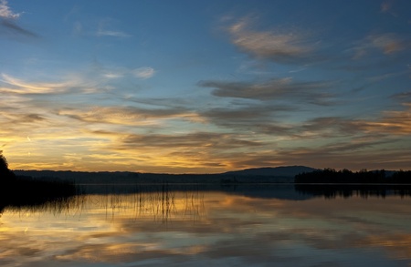 a lake during sunset with reflections of the coudsの写真素材