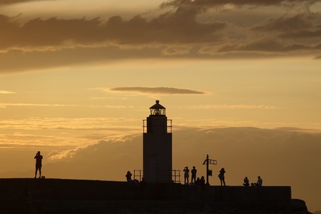 Pier with lighthouse after the stormの写真素材