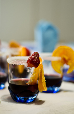 drink made with watermelon, an orange slice and a strawberry with glass board sprinkled with sugarの写真素材
