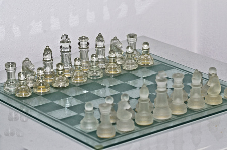 Transparent and opaque chess on glass chessboardの写真素材