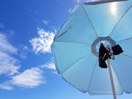 Blue sea umbrella under the summer skyの写真素材